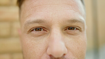 Young man close up of eyes smiling at street