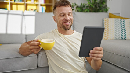 Young man having video call drinking coffee at home