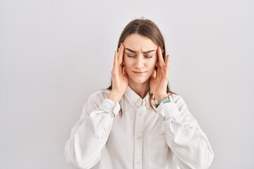 Young caucasian woman standing over isolated background with hand on head, headache because stress. suffering migraine.