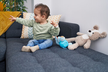 Naklejka premium Adorable hispanic boy smiling confident sitting on sofa at home
