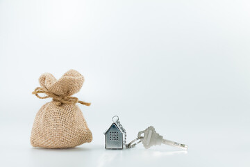 Money bag and key chain as house on white background, saving money for buy a new home and real...