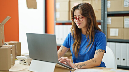 Young beautiful hispanic woman ecommerce business worker using laptop working at office