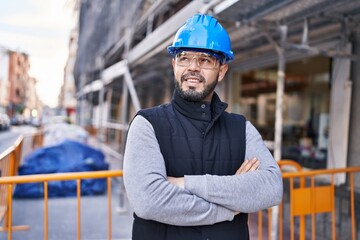 Young latin man architect smiling confident standing with arms crossed gesture at street