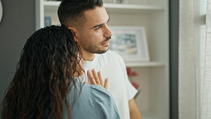 Man and woman couple consoling boyfriend standing at home