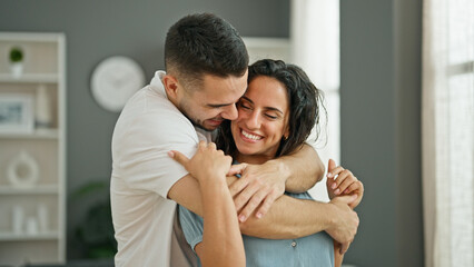 Man and woman couple hugging each other smiling at home