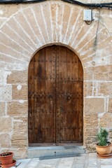 Fototapeta na wymiar Traditional, wooden entrance door with a detailed stone frame.