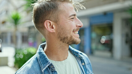 Young caucasian man smiling confident looking to the side at street