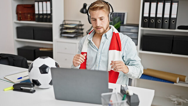 Young caucasian man business worker watching soccer game with winner gesture at office