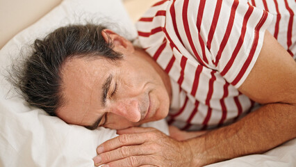 Middle age man lying on bed sleeping at bedroom