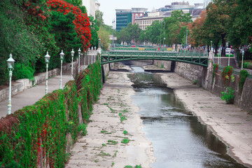 Pedestrian bridge over the water canal in Vienna , Austria . Stadtpark public park in Vienna 