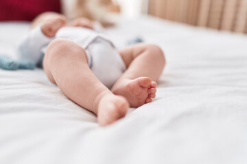 Adorable caucasian baby smiling confident lying on bed at bedroom