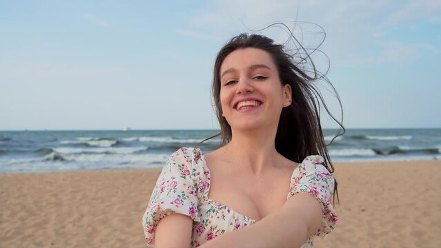 Beautiful young woman laughing and smiling with her boyfriend on beach at sunset. Spinning around, uninstalling taking hands, honeymoon. Relax leisure activity, active lifestyle, cheerful confident