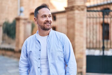 Young caucasian man smiling confident looking to the side at street