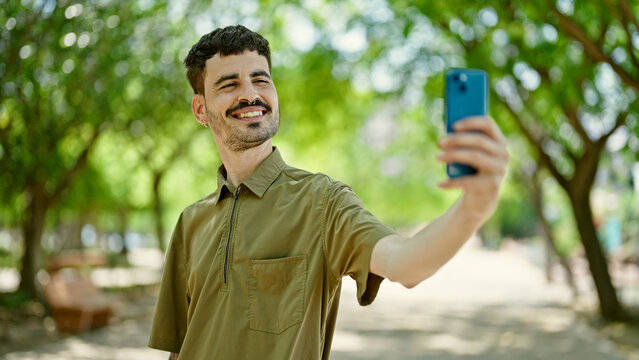 Young hispanic man smiling confident making selfie by the smartphone at park
