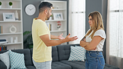 Man and woman couple standing together arguing at home