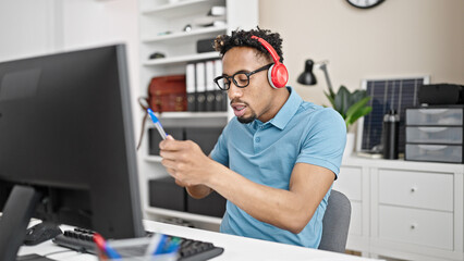 African american man business worker listening to music doing drummer gesture at office