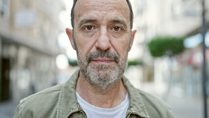 Middle age man standing with serious expression at street © Krakenimages.com