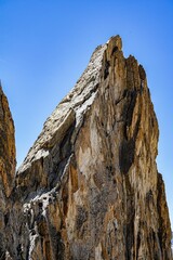 Vertical shot of a rocky cliff formation isolated on the background if blue sky