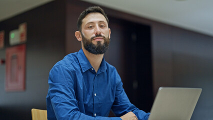 Young hispanic man business worker using laptop working at the office