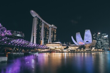 Aerial view of a  nighttime view of the Singapore skyline, illuminated by city lights