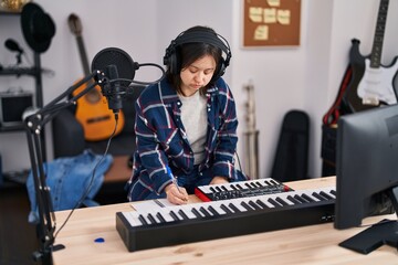 Young woman with down syndrome musician composing song at music studio