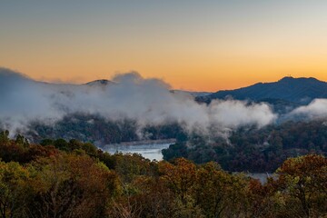 Landscape featuring a tranquil lake against a stunning backdrop of mountains at sunset
