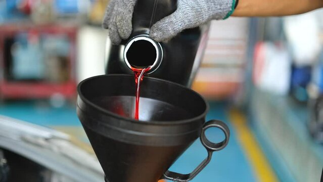 Car Mechanic Pouring Gear Fluid Into Transmission