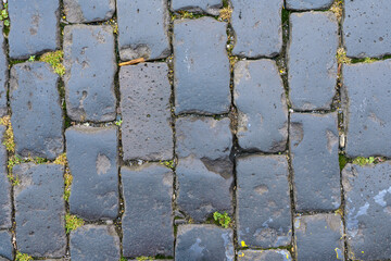 Old pavement with smooth black stones. Background, texture