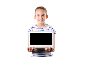 Cute little european girl holding modern silver laptop and smiling isolated on white background. Free space for your text on the display