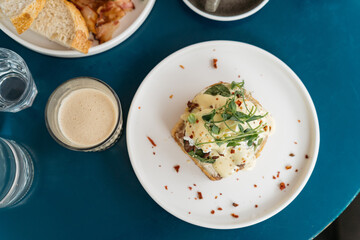 Delicious breakfast top view. Coffee and toast with eggs benedict with roast beef and hollandaise sauce