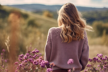 A girl wearing a pink sweater, enjoying a scenic autumn walk.