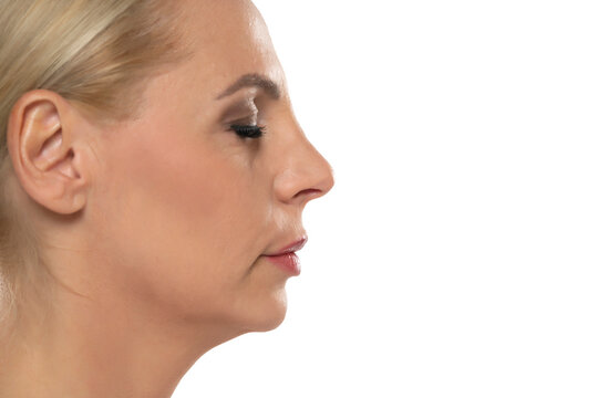 Profile of senior middle aged blond woman with nose job on white background