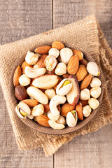Healthy mix nuts on wooden background. Almonds, hazelnuts, cashews, peanuts, pistachios, Brazilian nuts