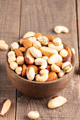 Healthy mix nuts on wooden background. Almonds, hazelnuts, cashews, peanuts, pistachios, Brazilian nuts