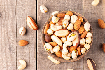 Healthy mix nuts on wooden background. Almonds, hazelnuts, cashews, peanuts, pistachios, Brazilian nuts