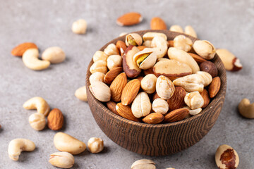 Healthy mix nuts on wooden background. Almonds, hazelnuts, cashews, peanuts, pistachios, Brazilian nuts