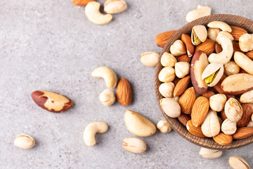 Healthy mix nuts on wooden background. Almonds, hazelnuts, cashews, peanuts, pistachios, Brazilian nuts