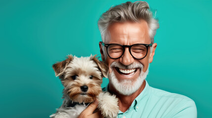 Senior man holds a dog puppy in his arms on blue background. - Powered by Adobe