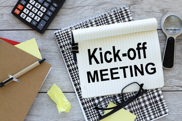 Kick-Off Meeting text on an open notebook. calculator