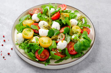 Caprese Salad with Cherry Tomatoes and Pesto Sauce over Bright Background