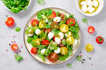 Caprese Salad with Cherry Tomatoes and Pesto Sauce over Bright Background