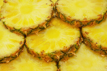 Pineapple juicy yellow slices as a background.