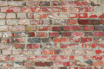 Naklejka premium Zdjęcie przedstawiające teksturę utworzoną przez cegły ułożone w równych rzędach w murze. Cegły częściowo pokryte są zaprawą murarską. Stanowią one element starej budowli.