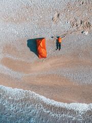 aerial view stock photo showcases a beach camping scene where a man's tent is arranged in a flat...