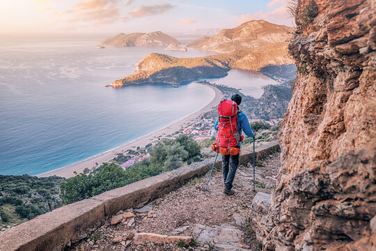 Happy hiker man with trekking backpack at a viewpoint of Lycian Way trail in Oludeniz, Fethiye. Travel and adventure in Turkey