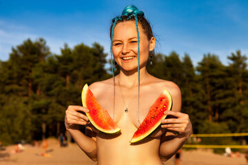 Smiling naturist lady posing close up watermelon naked on beach, looking at camera. Perfect nude...