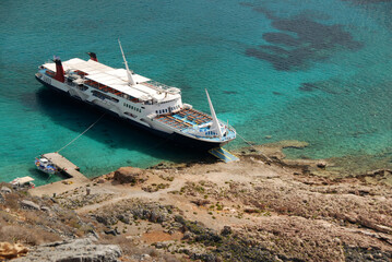 Cruise ship moored to the wild coast. Mediterranean Sea. Turquoise sea water. Bird's-eye view. Wild...