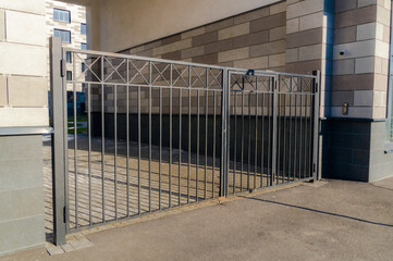 The black gate in front of the entrance to the courtyard of an apartment building