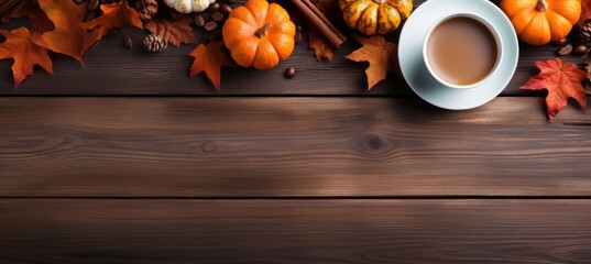 Mug of coffee and autumn leaves with orange pumpkin on wooden table. Autumn drink concept.