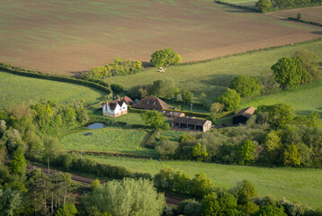 Aerial view of a farm and surrounding fields in the countryside in Kent, UK